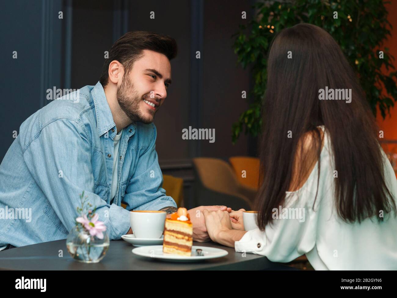 Coppia In Amore Sorridente L'Uno L'Altro Avendo Caffè Nel Caffè Foto Stock