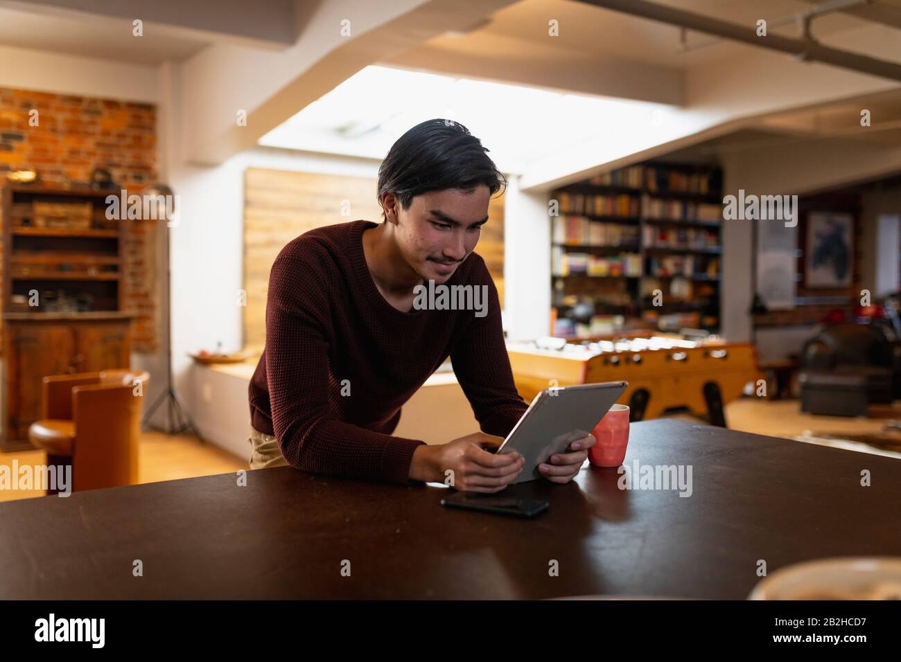 Giovane uomo che usa un touchpad a casa Foto Stock