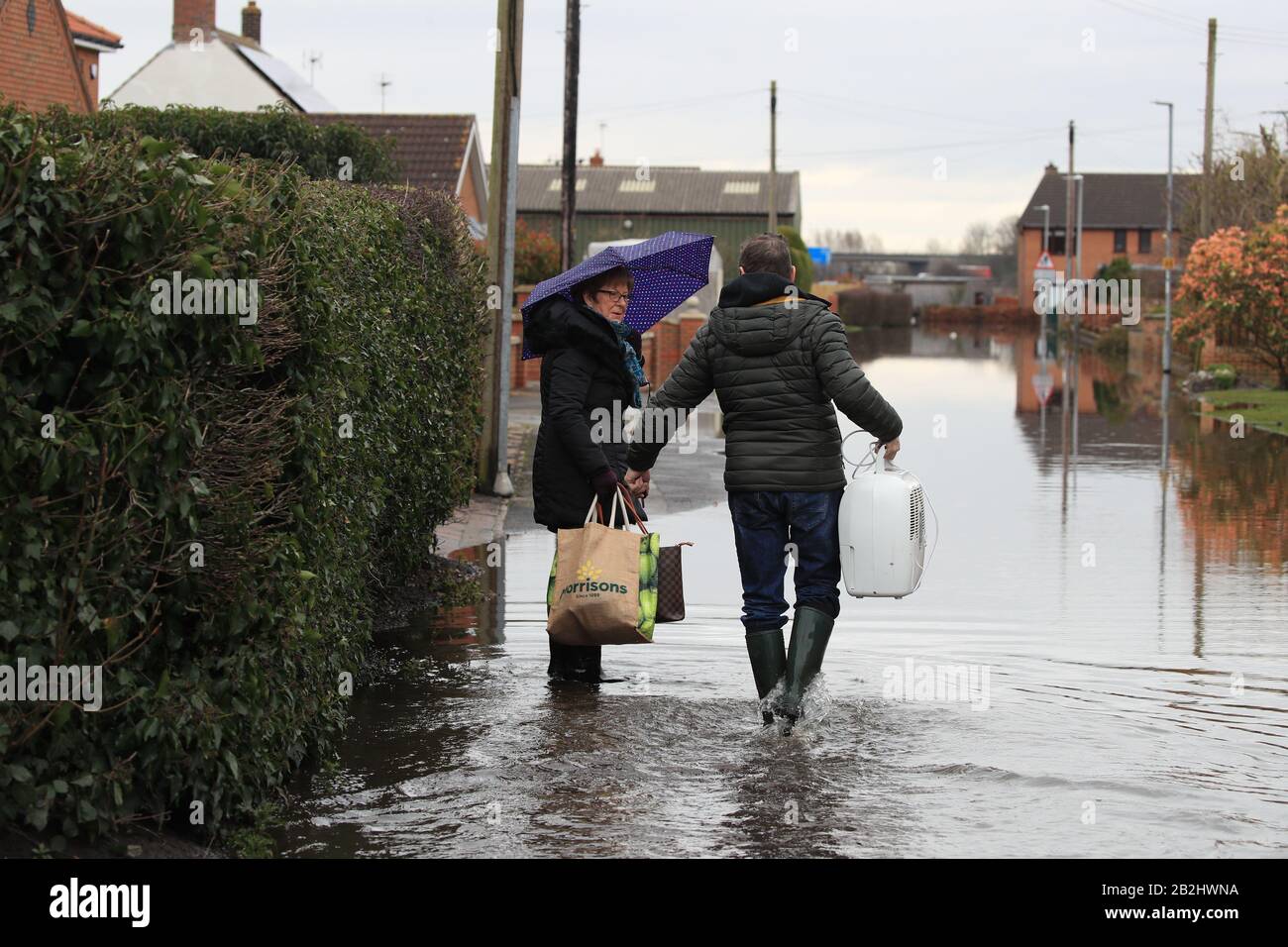 Residenti locali in acque alluvionali a East Cowick, nello Yorkshire, in totale 82 moniti di alluvione sono ancora in vigore per l'Inghilterra, il Galles e la Scozia dopo gli effetti di Storm Jorge nel fine settimana. Foto Stock