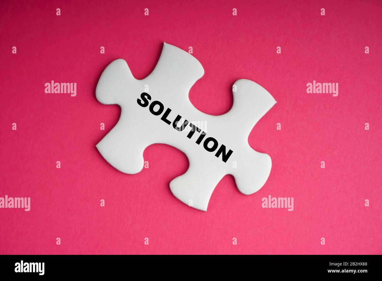 Testo della soluzione con puzzle bianco su sfondo rosa. Concetto di business e motivazione Foto Stock