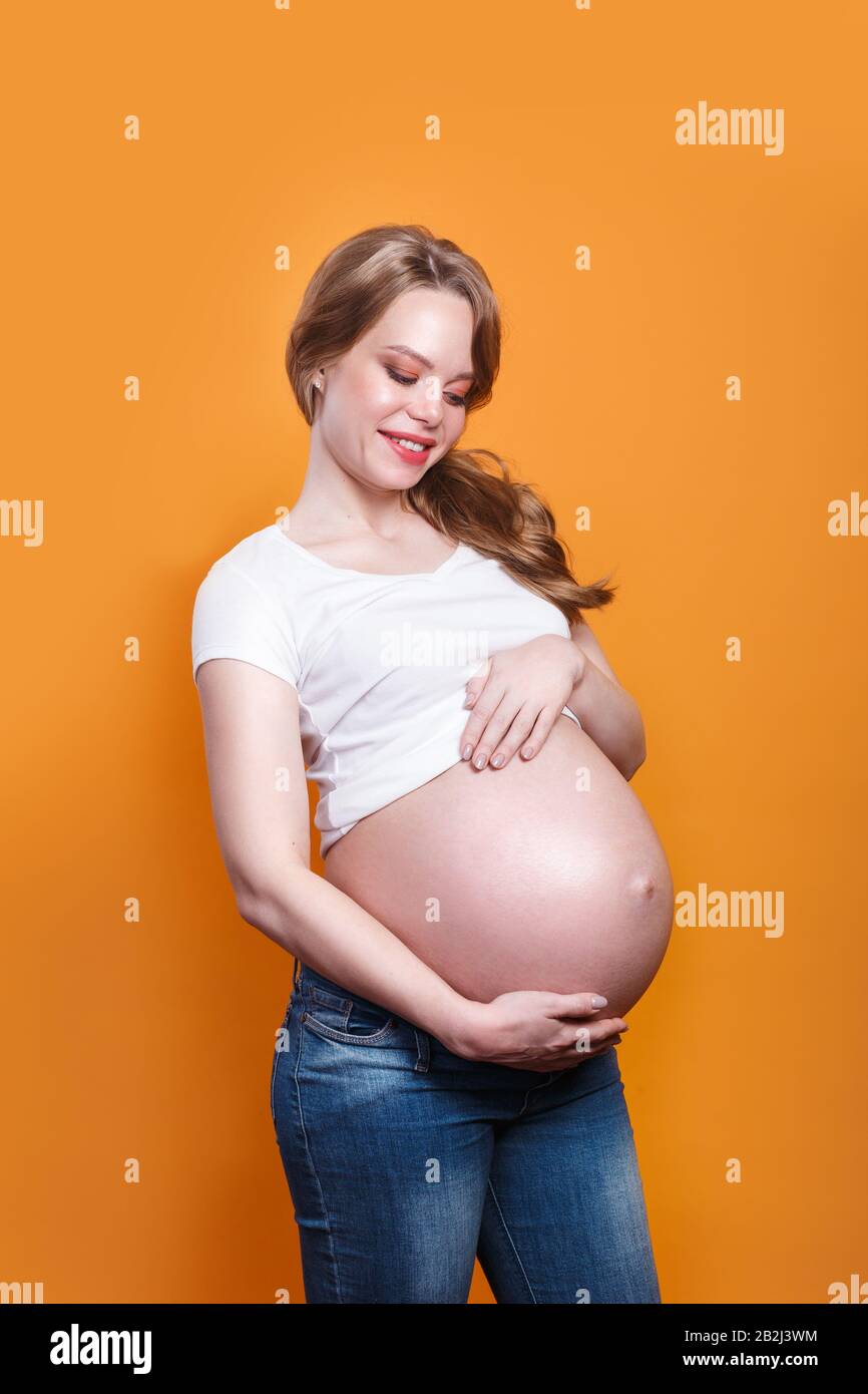 Bella donna che si aspetta un bambino e stondola il suo ventre. Gravidanza Foto Stock