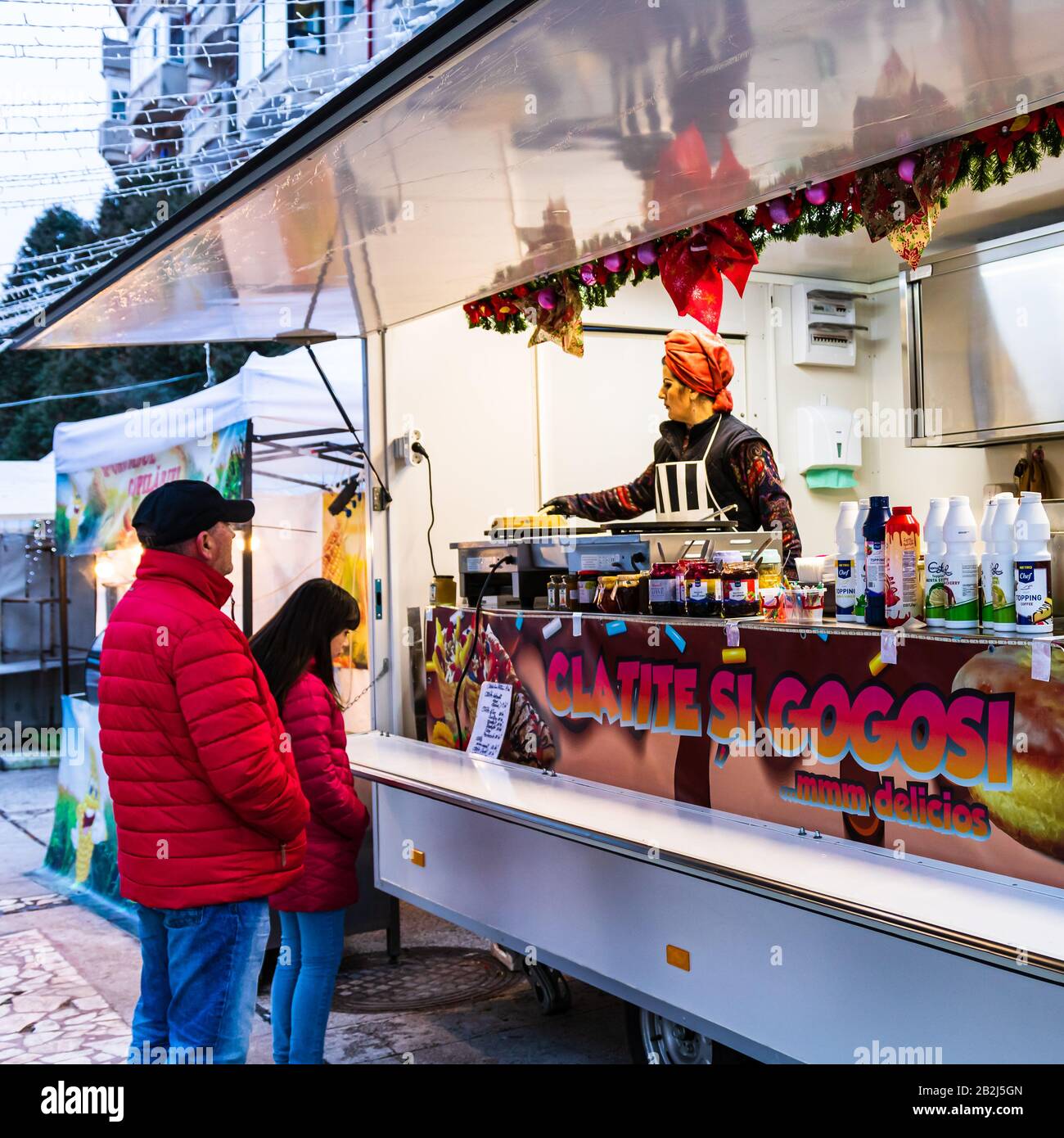 La gente che aspetta per comprare i pancake o le ciambelle ad un festival di alimento a Targoviste, Romania, 2020. Foto Stock