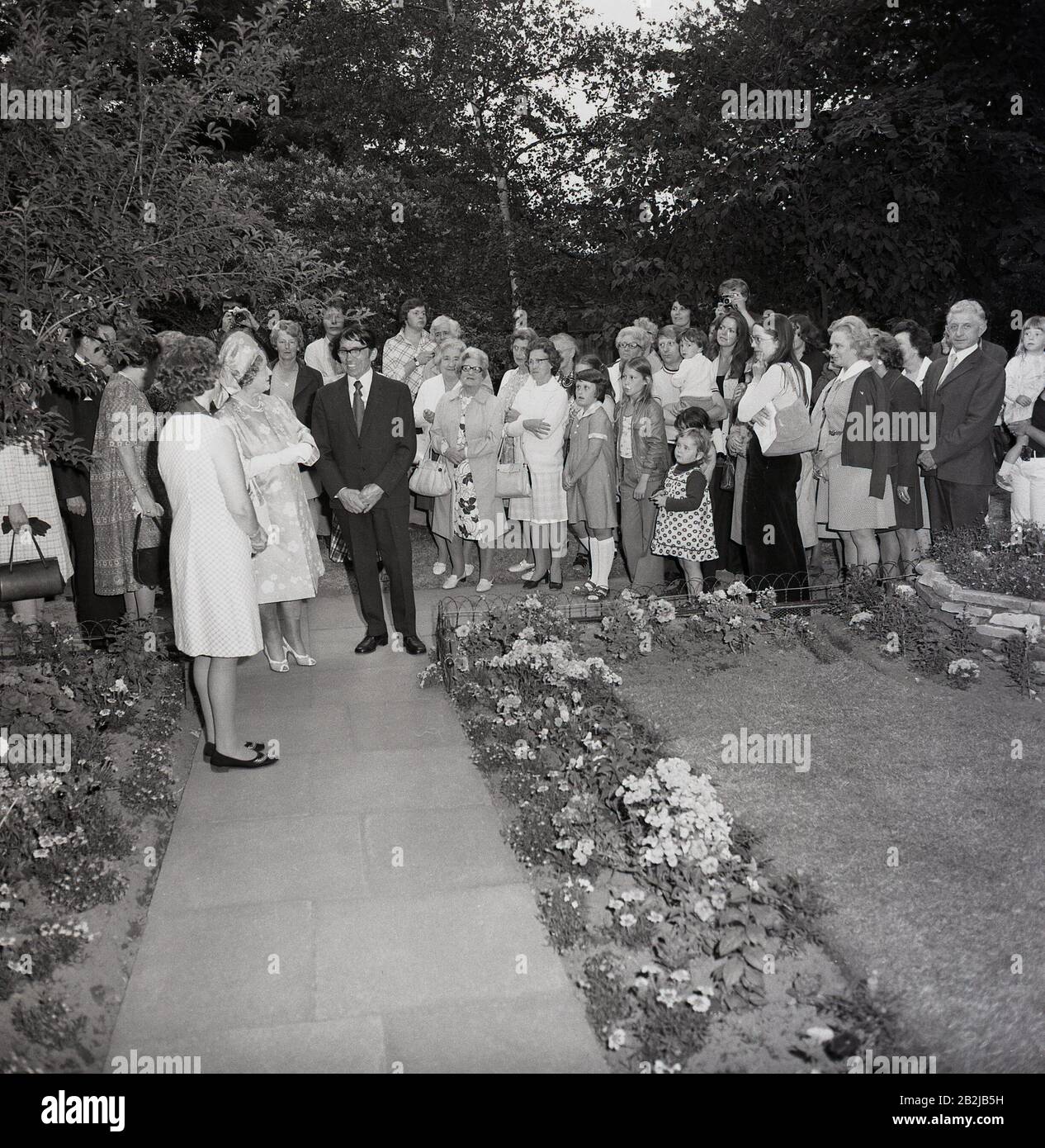 Anni '1970, storia, bambini e gente del posto si riuniscono per dare il benvenuto alla Regina madre mentre visita una casa in un sobborgo di South London, Inghilterra, Regno Unito. Foto Stock