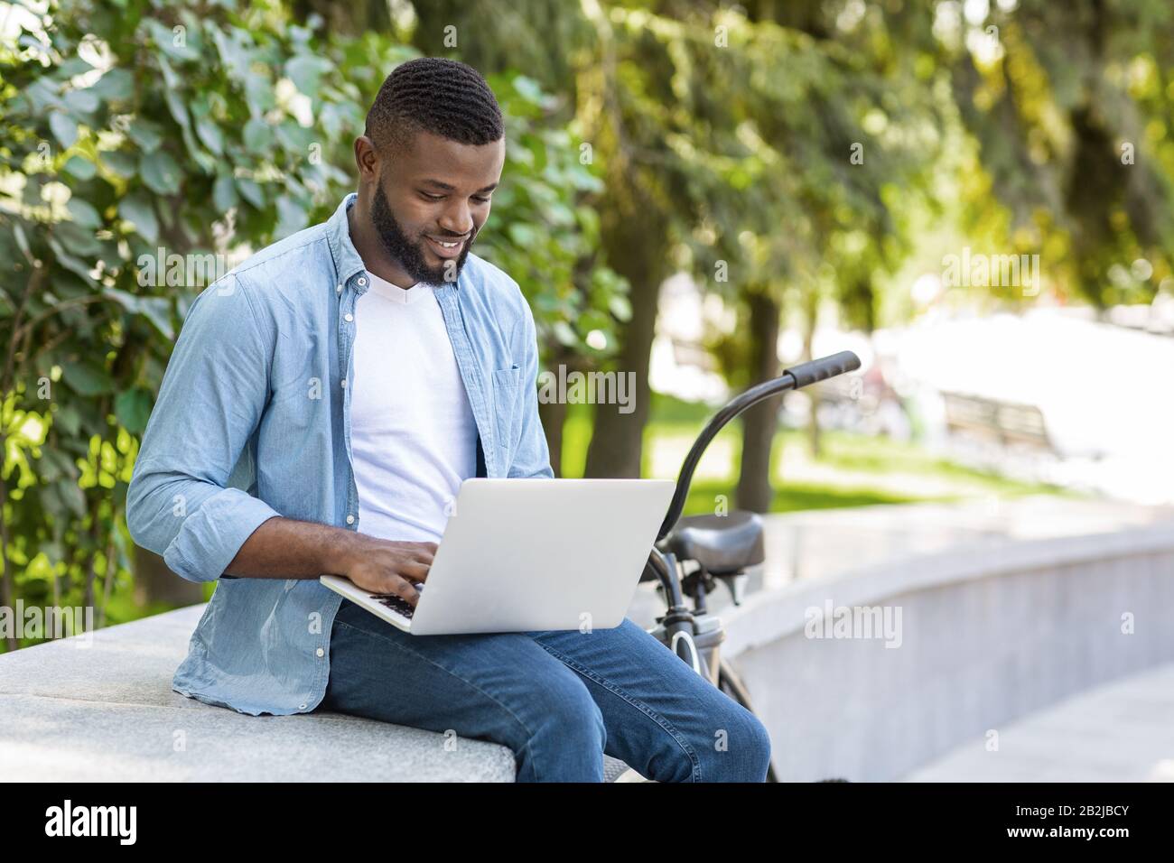 Bel Freelancer Guy Americano Aferican Che Lavora Su Laptop In Park Foto Stock