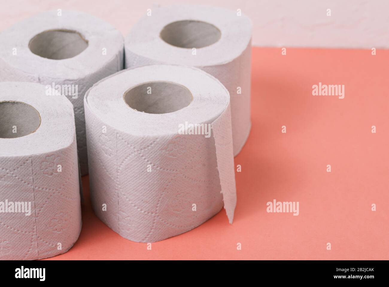 Carta igienica su sfondo rosa con spazio per la copia. Forniture sanitarie e per uso domestico Foto Stock