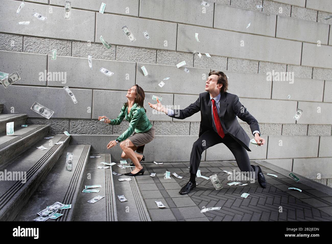 Busines uomo e donna che cattura denaro cadendo su gradini Foto Stock