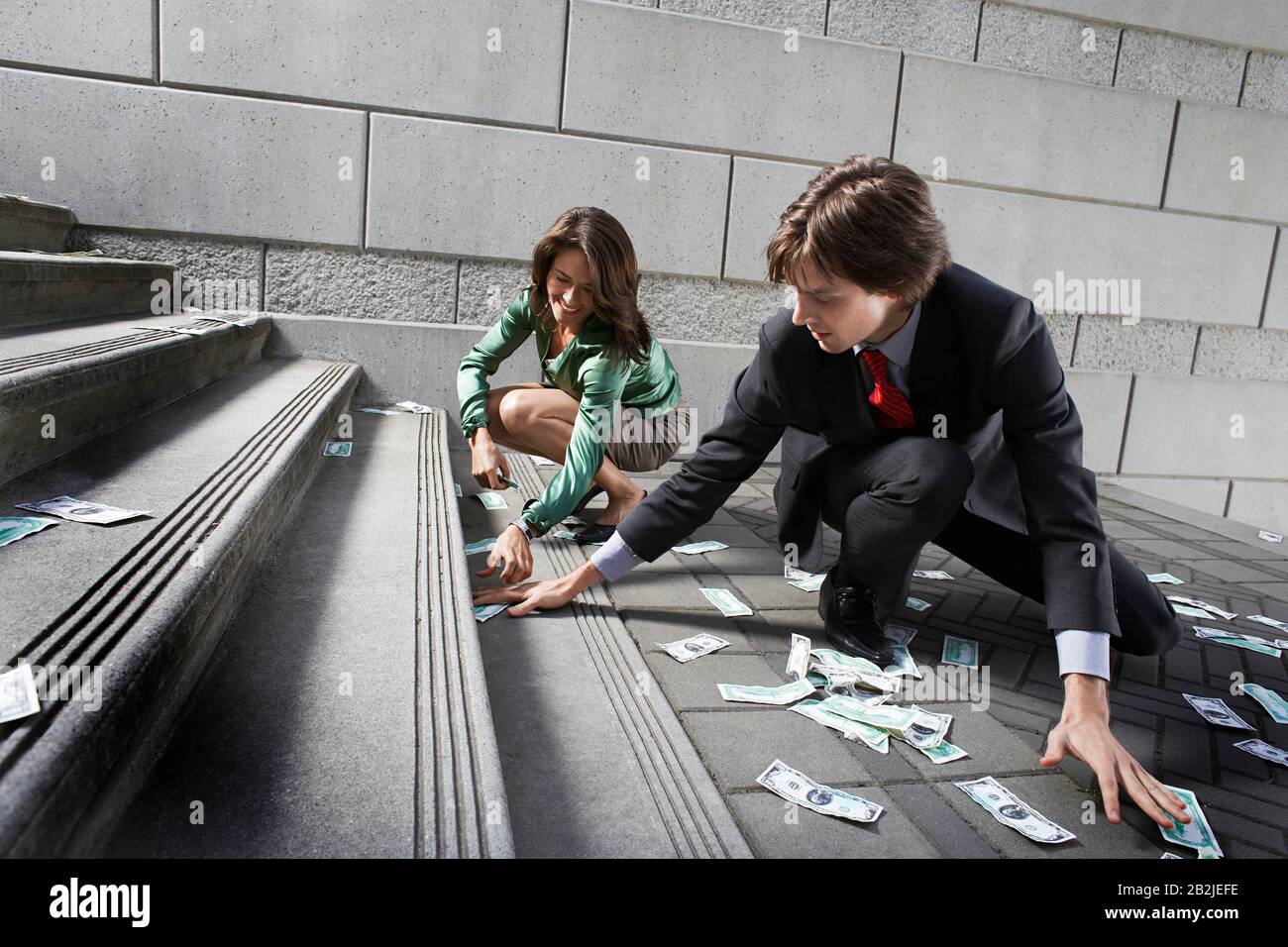 Busines uomo e donna che raccolgono soldi su gradini Foto Stock
