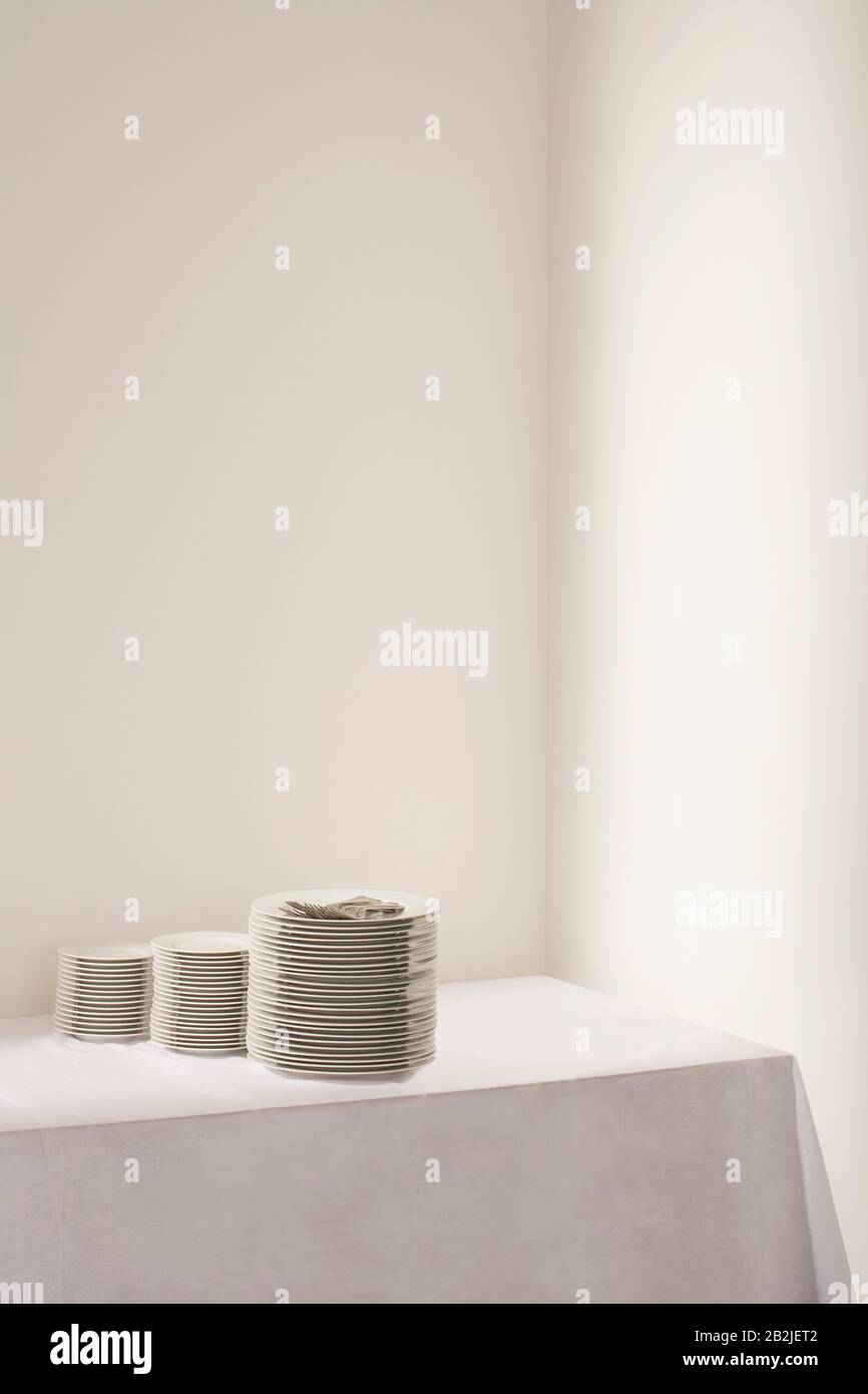 Tre pile di piatti e posate sul tavolo Foto Stock