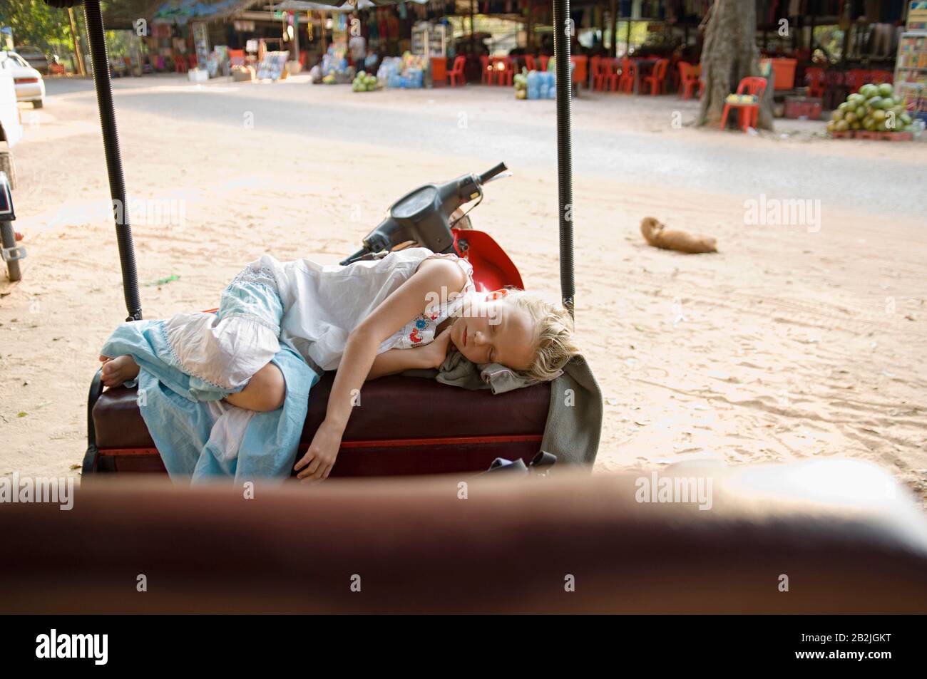 Piccola ragazza che dorme sulla sede di Rickshaw Foto Stock