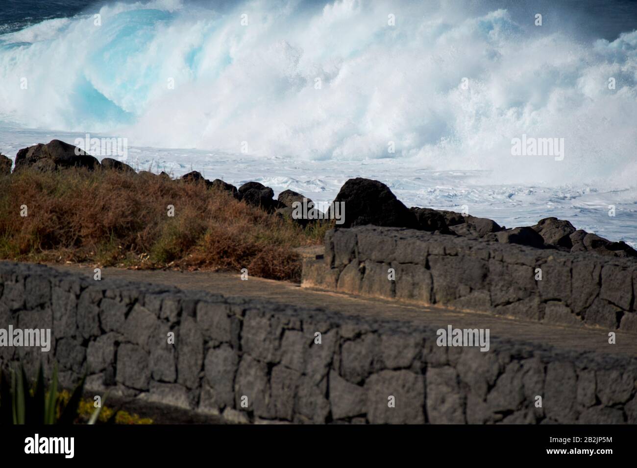 Onde che si infrangono in mare al largo del sentiero costiero sul litorale delle isole canarie di Lanzarote spagna Foto Stock