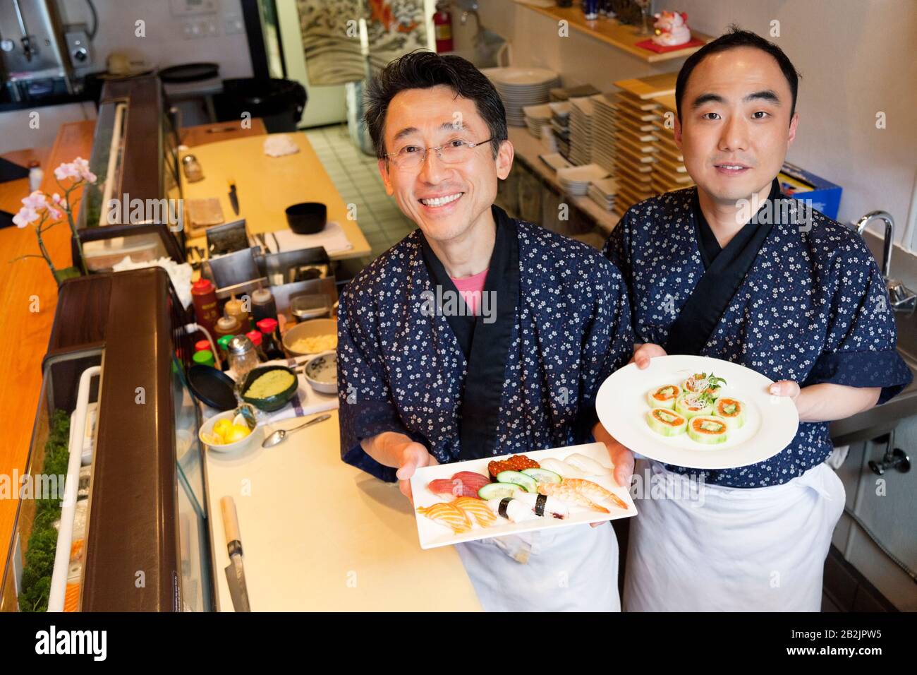 Chef felici con cucina asiatica preparata nel ristorante Foto Stock