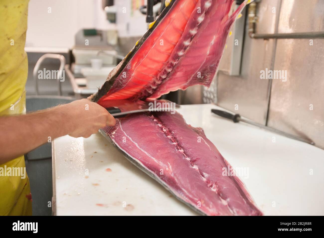 Uomo che taglia il pesce con coltello da cucina Foto Stock