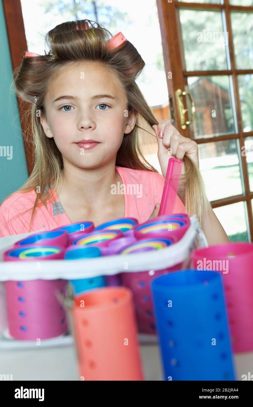 Bambina che mette i rulli in capelli Foto Stock