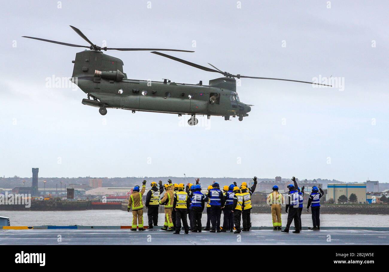 Un elicottero Chinook esegue un cavalcavia mentre i membri dell'equipaggio vi si adatterono dal ponte del vettore aereo della Royal Navy HMS Prince of Wales, che si trova di fronte al Royal Liver Building, dopo essere attraccato a Liverpool per una visita della città per una settimana. Foto PA. Data Immagine: Martedì 3 Marzo 2020. Photo credit dovrebbe leggere: Peter Byrne/PA Filo Foto Stock