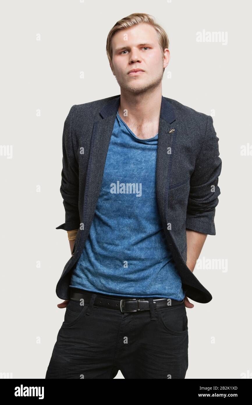 Ritratto di giovane uomo d'affari fiducioso in Smart casuals su sfondo grigio Foto Stock