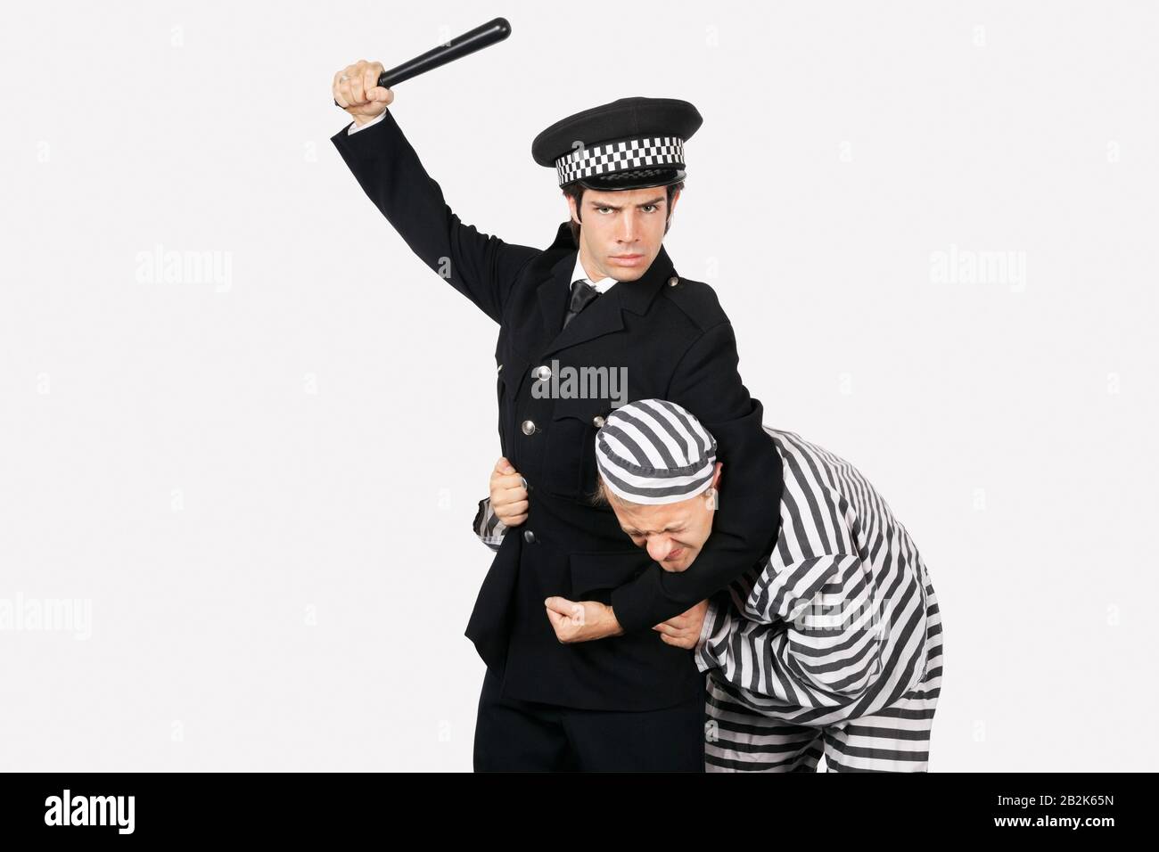 Ritratto di ufficiale di polizia con bastone da notte che arrestò prigioniero maschio su sfondo grigio Foto Stock