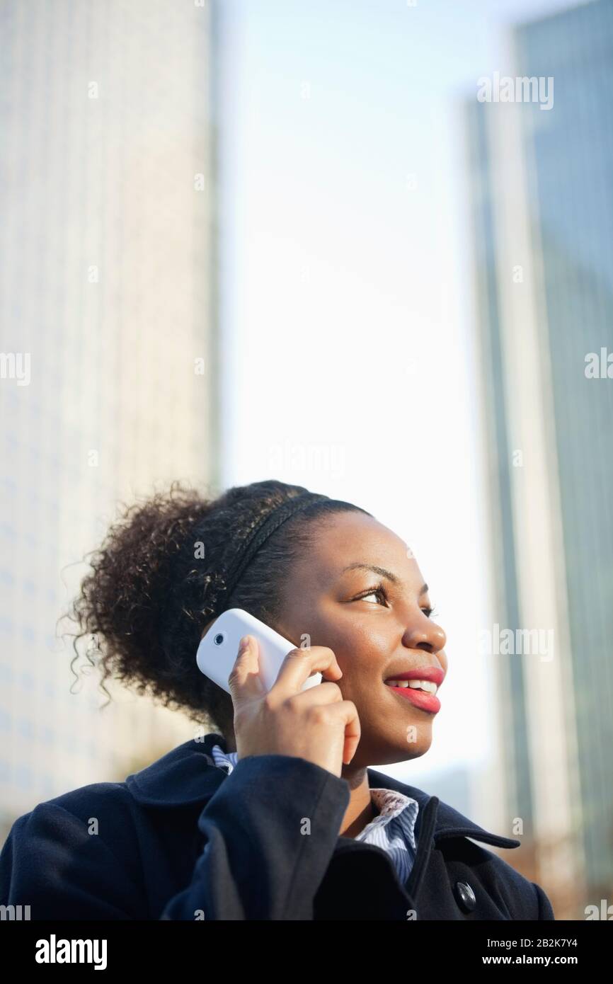 Giovane donna afroamericana sorridente che usa il telefono cellulare Foto Stock