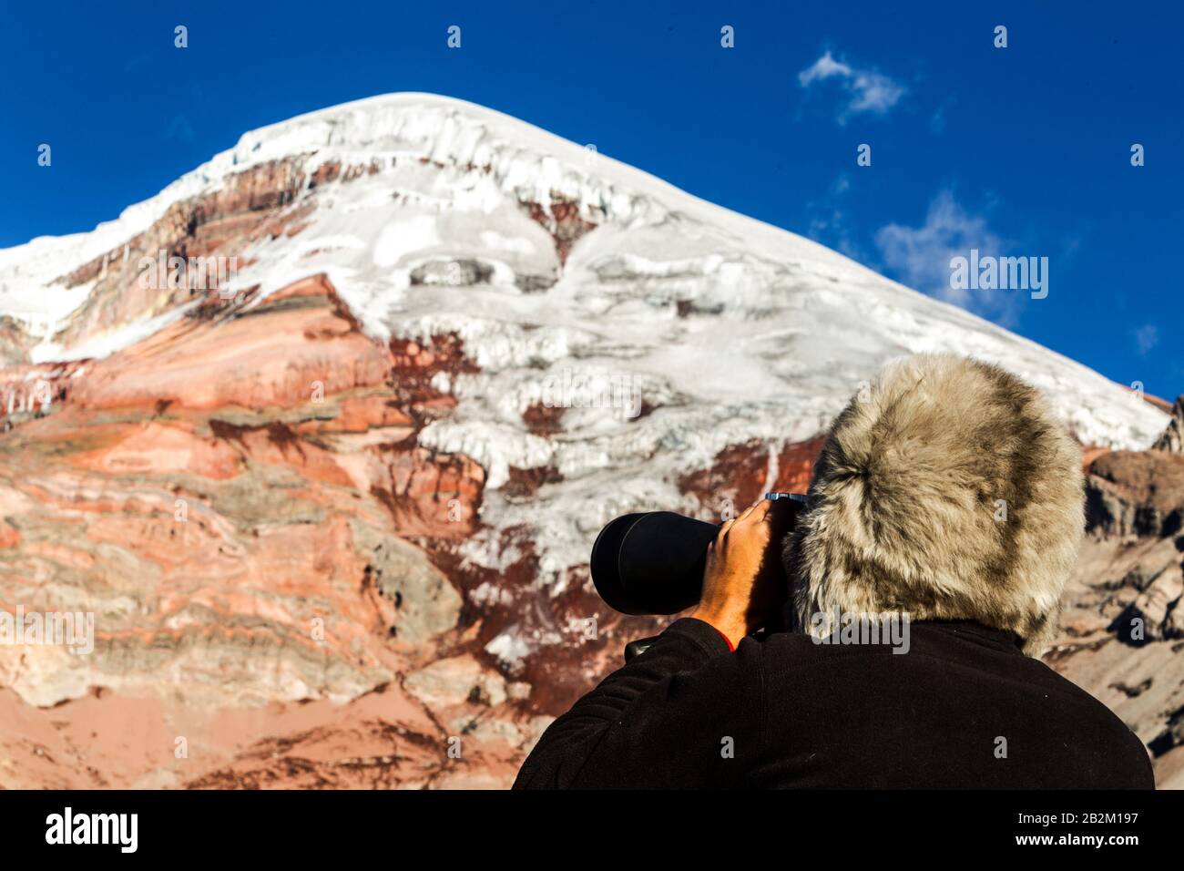 Il Tracker di montagna a studiare il picco del Vulcano Chimborazo per Valanghe con un enorme Binocolo Alpaca Hat Foto Stock