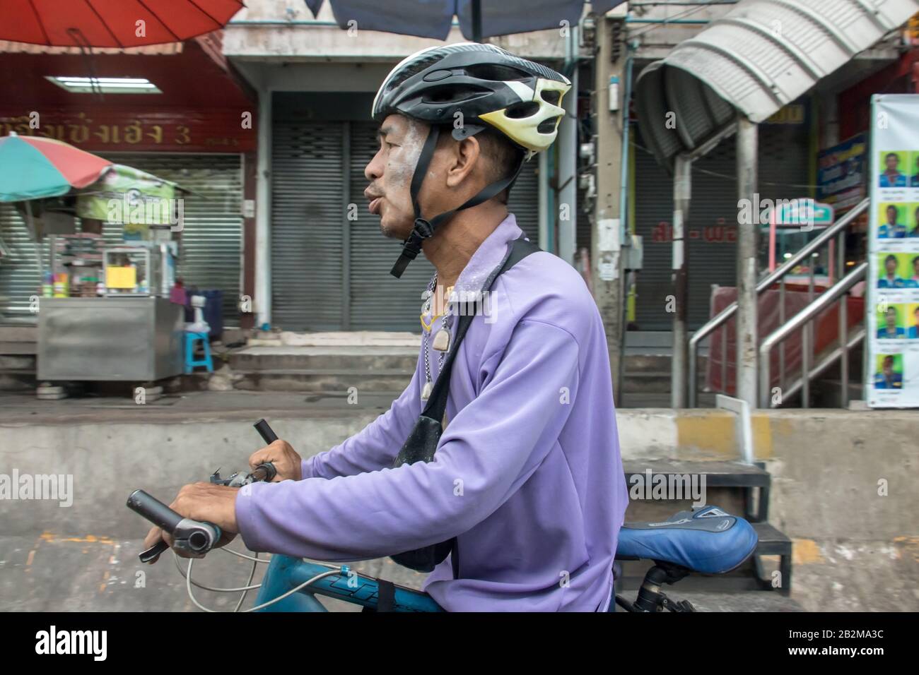 Samut PRAKAN, THAILANDIA, 21 SETTEMBRE 2019, un ciclista con casco che spinge la bicicletta sulla strada della città. Foto Stock