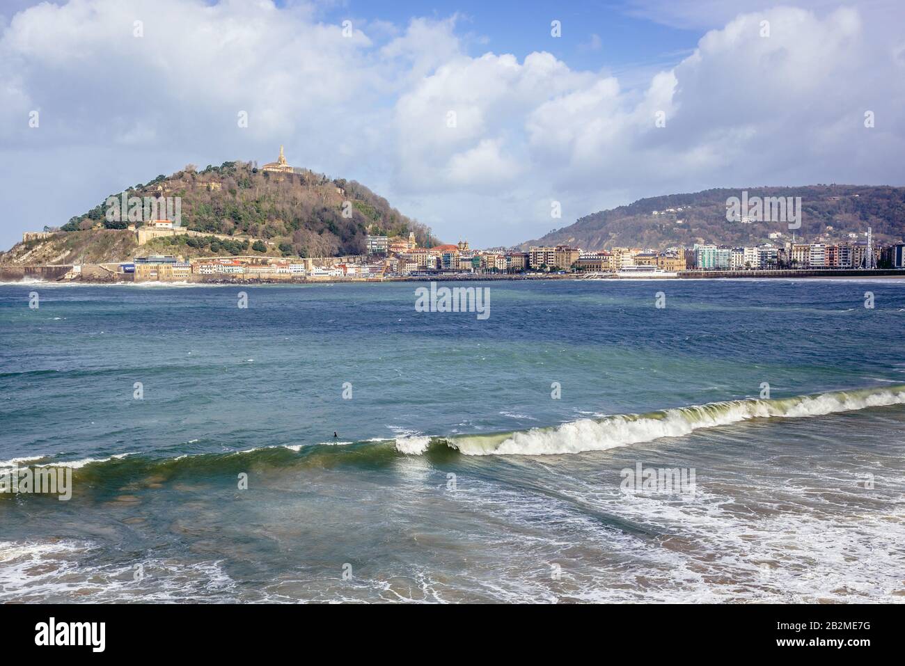 Vista con il monte Urgull con la statua di Gesù Cristo sulla baia di la Concha a San Sebastian città costiera situata nella comunità autonoma basca, Spagna Foto Stock