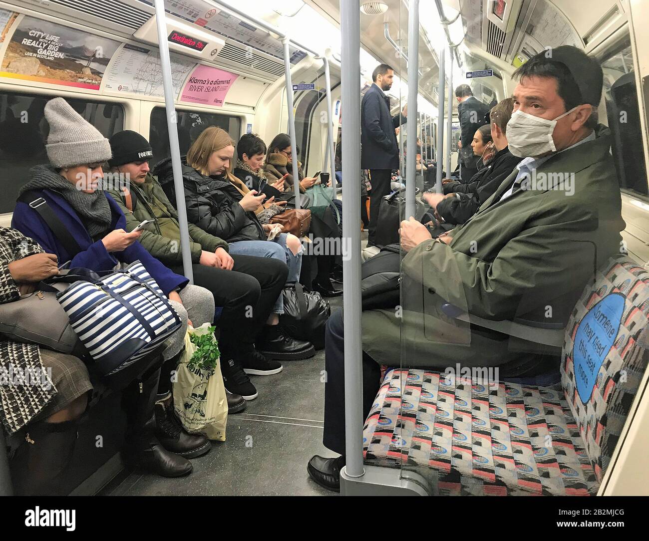 Un uomo sulla linea Jubilee della rete metropolitana di Londra indossando un facemask protettivo il giorno che il segretario di Heath Matt Hancock ha detto che il numero di persone diagnosticate con coronavirus nel Regno Unito è salito a 51. Foto Stock