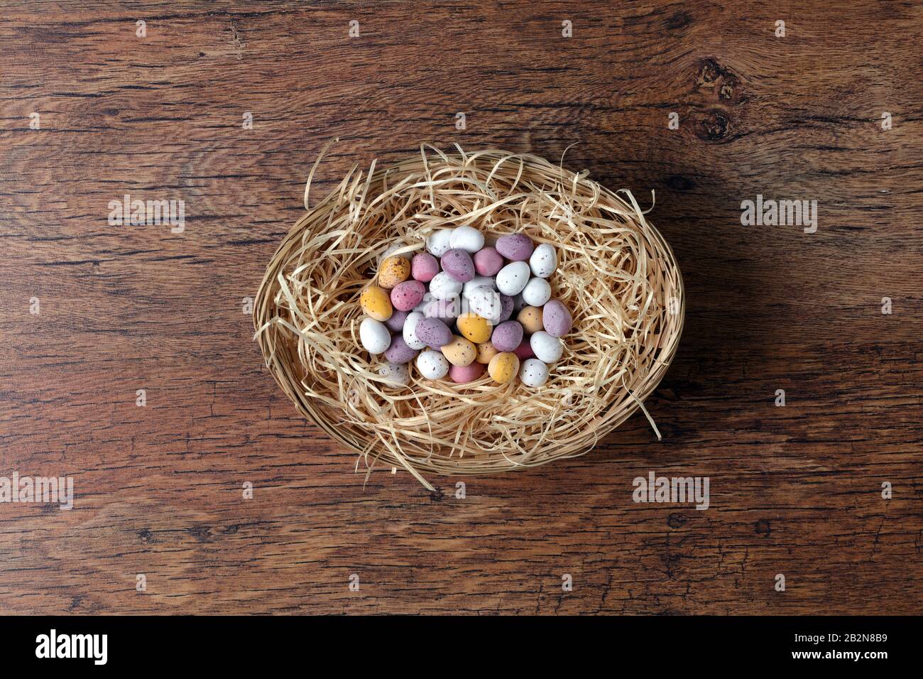 Gruppo di uova di Pasqua in un cesto con vecchio sfondo di legno Foto Stock