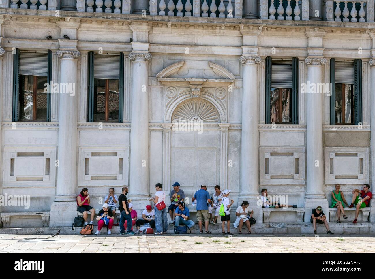 Turisti che mangiano e si siedono su gradini di un edificio, Venezia, italia. Nuove leggi a Venezia Italia contro i turisti che si comportano male. Foto Stock