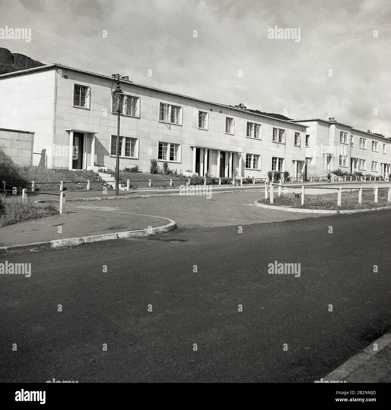 1950s, immagine storica, esterna che mostra una fila di nuove, moderne, due piani semi-indipendenti case, con tetti piani, Antrim, Irlanda del Nord. Foto Stock