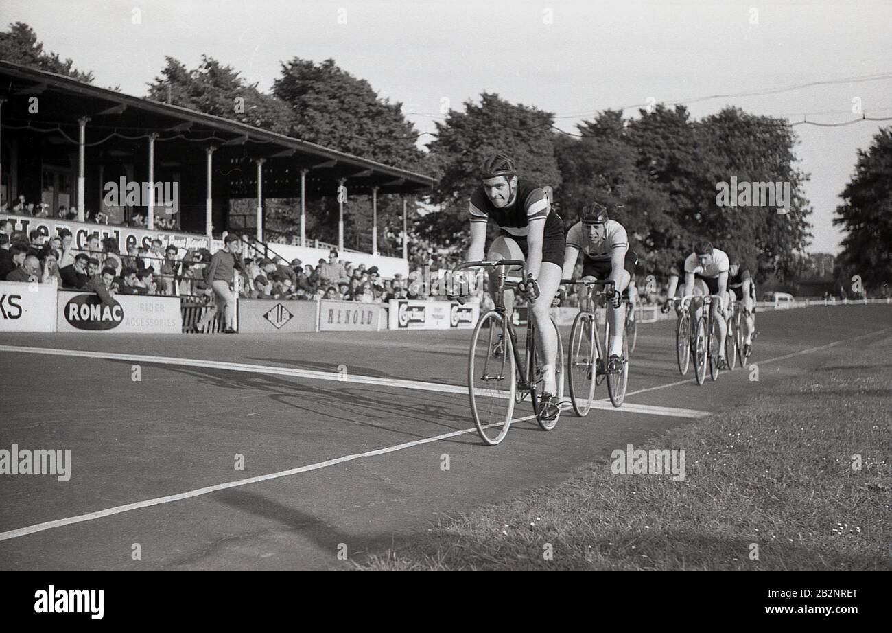 1950s, storico, gli spettatori nella tribuna che guardano i ciclisti di pista maschio che cavalcano al velodromo di Herne Hill a Dulwich, Londra meridionale, Inghilterra, una delle piste ciclabili più antiche del mondo, essendo stata costruita nel 1891. Ha ospitato gli eventi ciclistici del circuito delle Olimpiadi estive del 1948 ed è stata brevemente la sede del Crystal Palace FC durante la WW1. Foto Stock