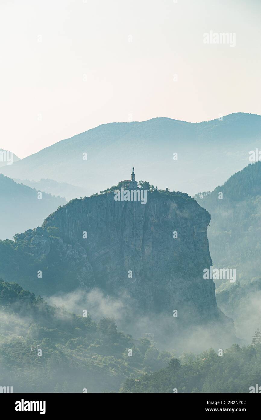 Una mattina mistrosa che si affaccia sulla piccola città di Castellane. Lo sperone roccioso di Notre-Dame si erge sopra la città. Foto Stock