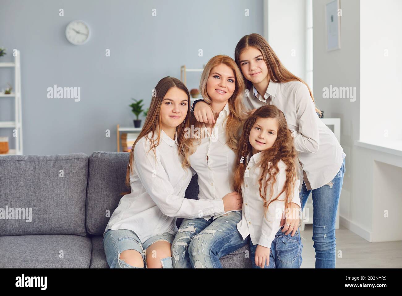 Buon giorno della madre. Una madre e tre figlie sul divano in camera. Foto Stock