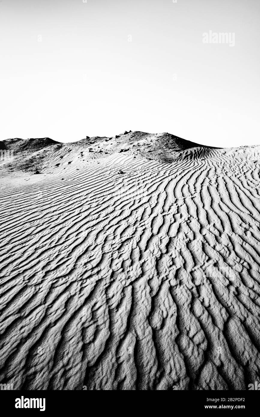 immagine in bianco e nero presa al crepuscolo, vista astratta di increspature di sabbia attraverso il deserto, Foto Stock