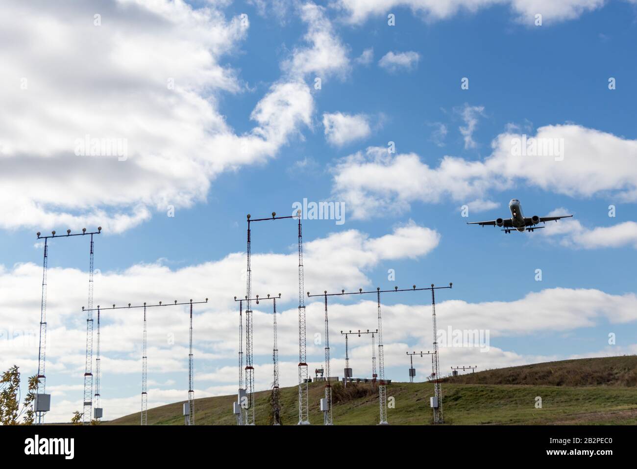 L'aereo si avvicina alla pista in una giornata parzialmente nuvolosa. Foto Stock