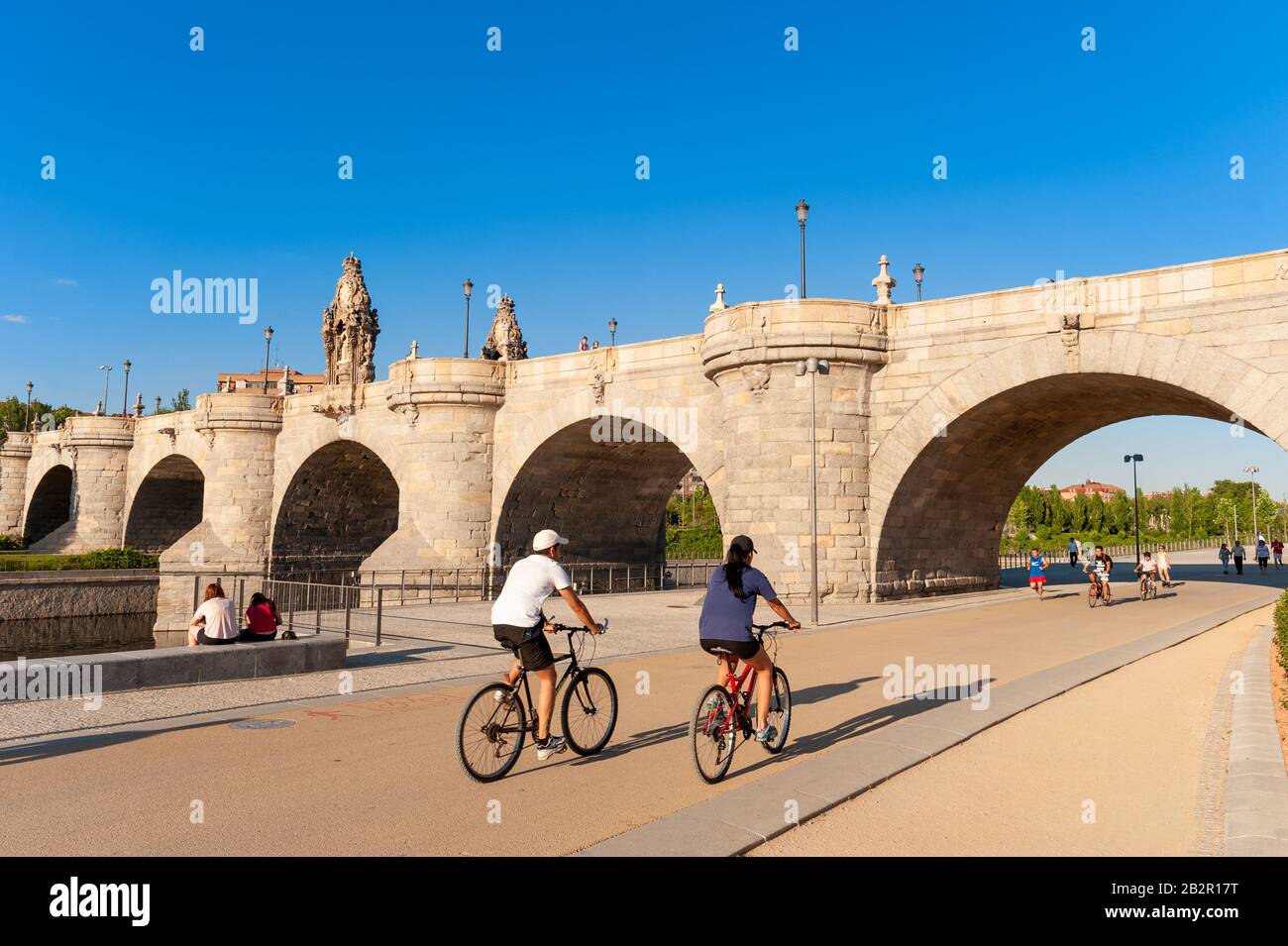 I ciclisti sulla Madrid Rio Park tratto del Anillo Verde avvicinando il Puente de Toledo, Madrid, Spagna Foto Stock