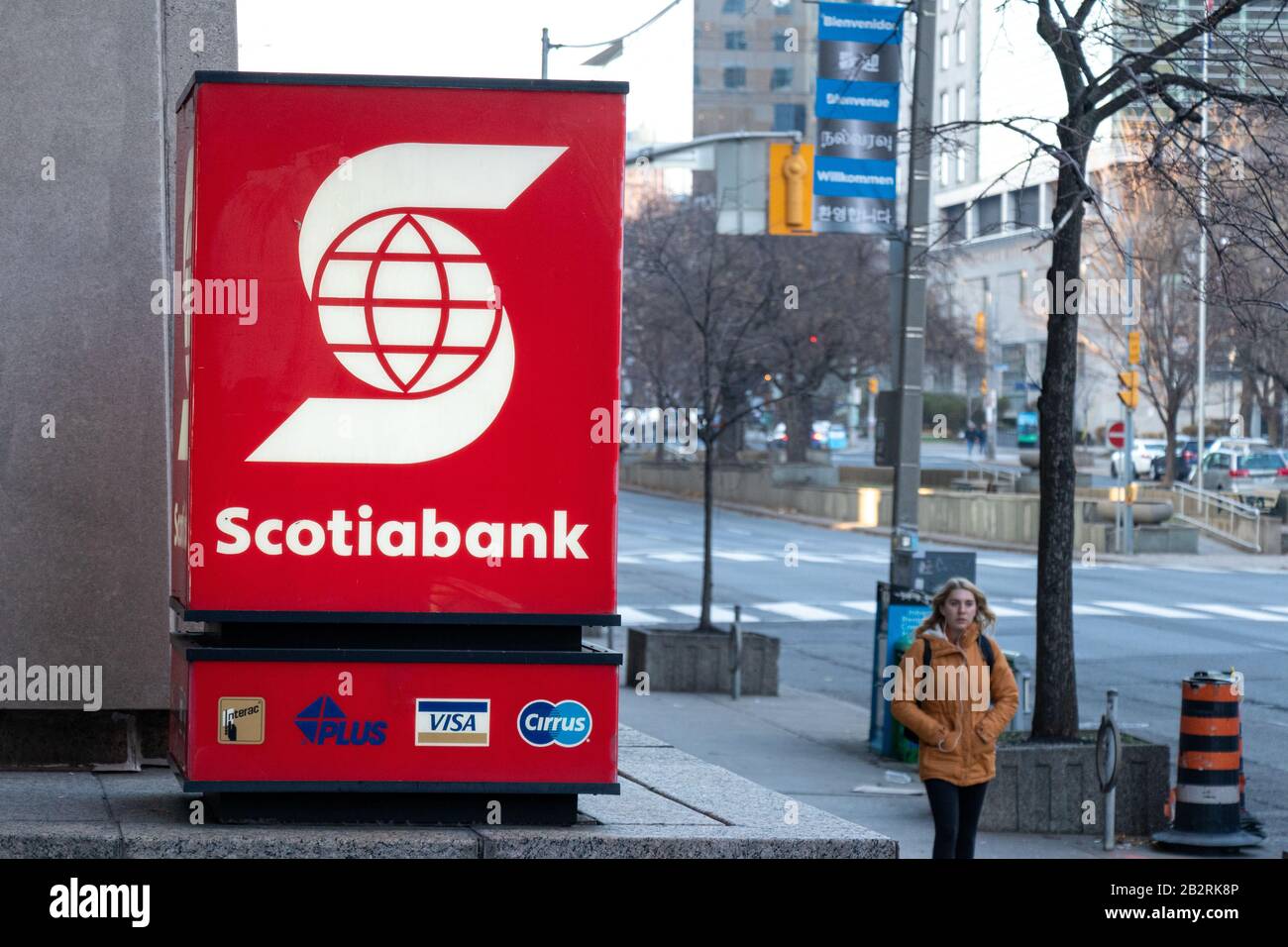 Scotiabank segno fuori-davanti ad una filiale della banca nel centro di Toronto come una donna cammina vicino. Foto Stock