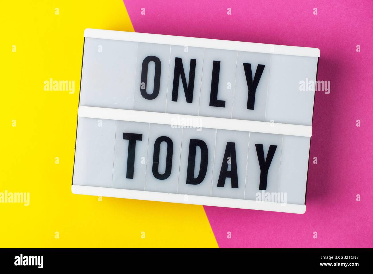 Solo oggi - testo su un display lightbox su sfondo giallo e rosa. Foto Stock