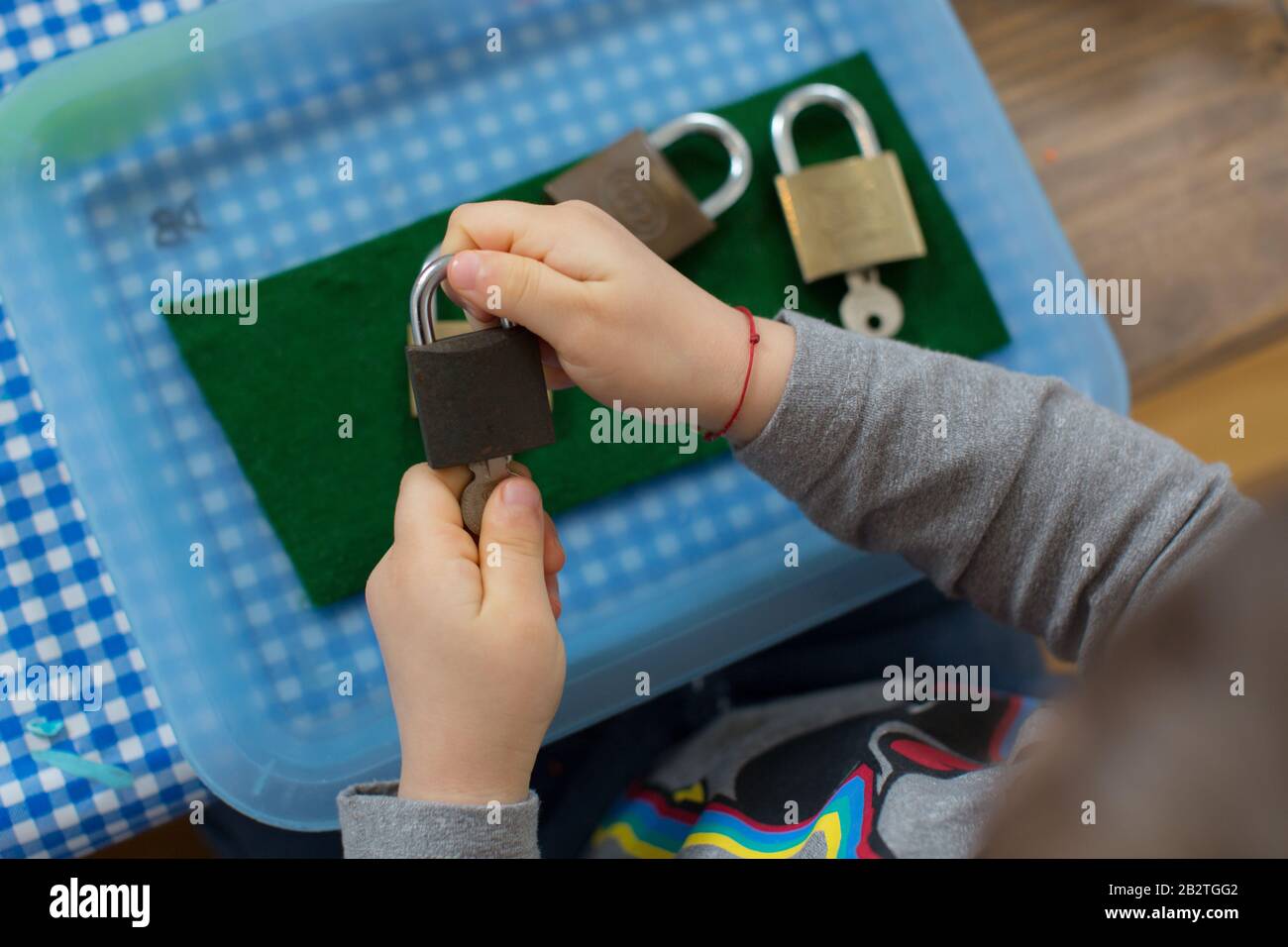 Primo piano di una mano dei bambini che gioca con i lucchetti, Montessori Foto Stock