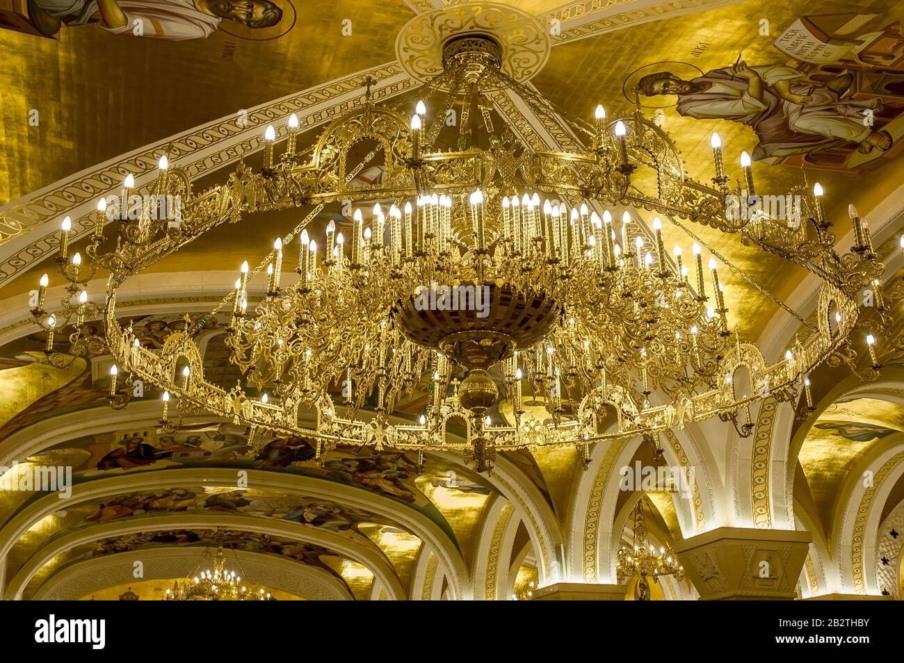 Belgrado, Serbia - 27 febbraio 2020: Un lampadario d'oro con affreschi e archi nella cripta della chiesa ortodossa di San Sava a Belgrado, in Serbia Foto Stock