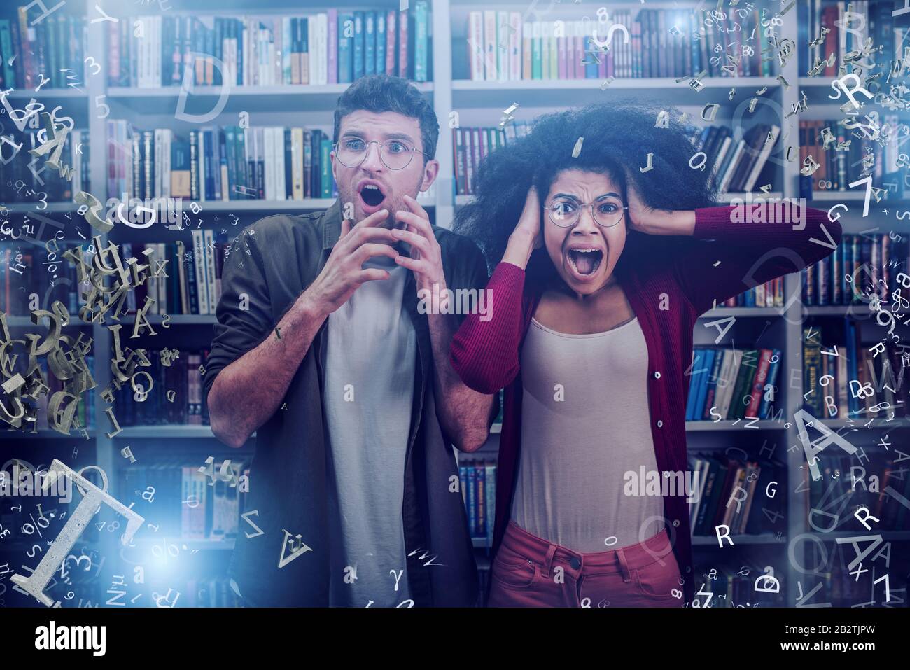 Gli studenti paurosi sono vittime di un incubus con lettere volanti. Concetto di stress per l'esame Foto Stock