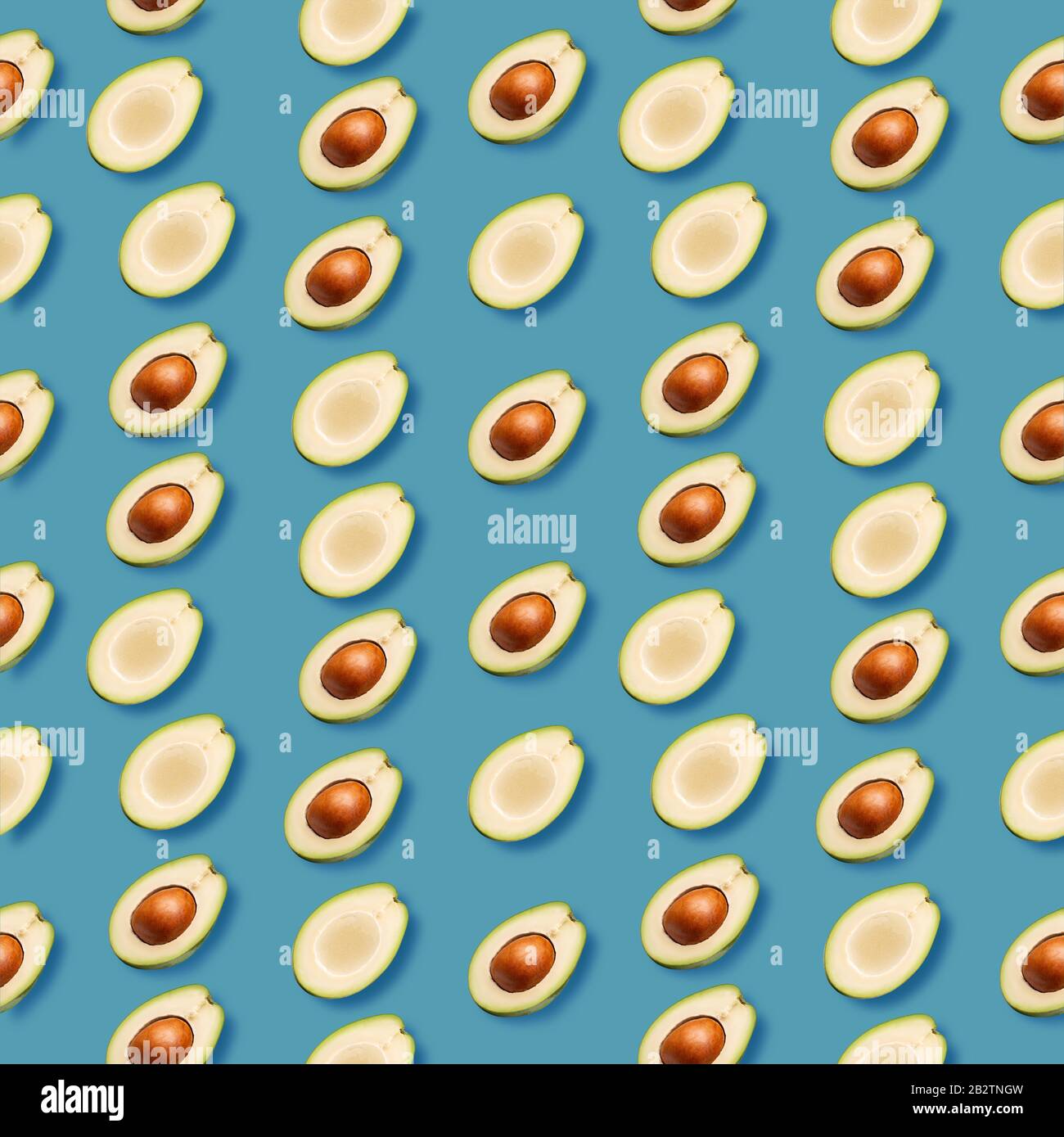 pattern con fette di avocado su sfondo blu. Foto Stock