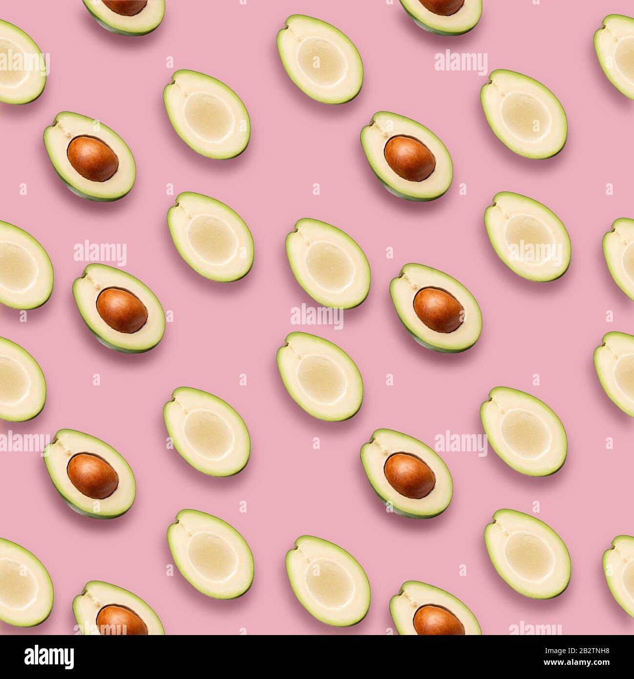 pattern con fette di avocado su sfondo rosa. Foto Stock