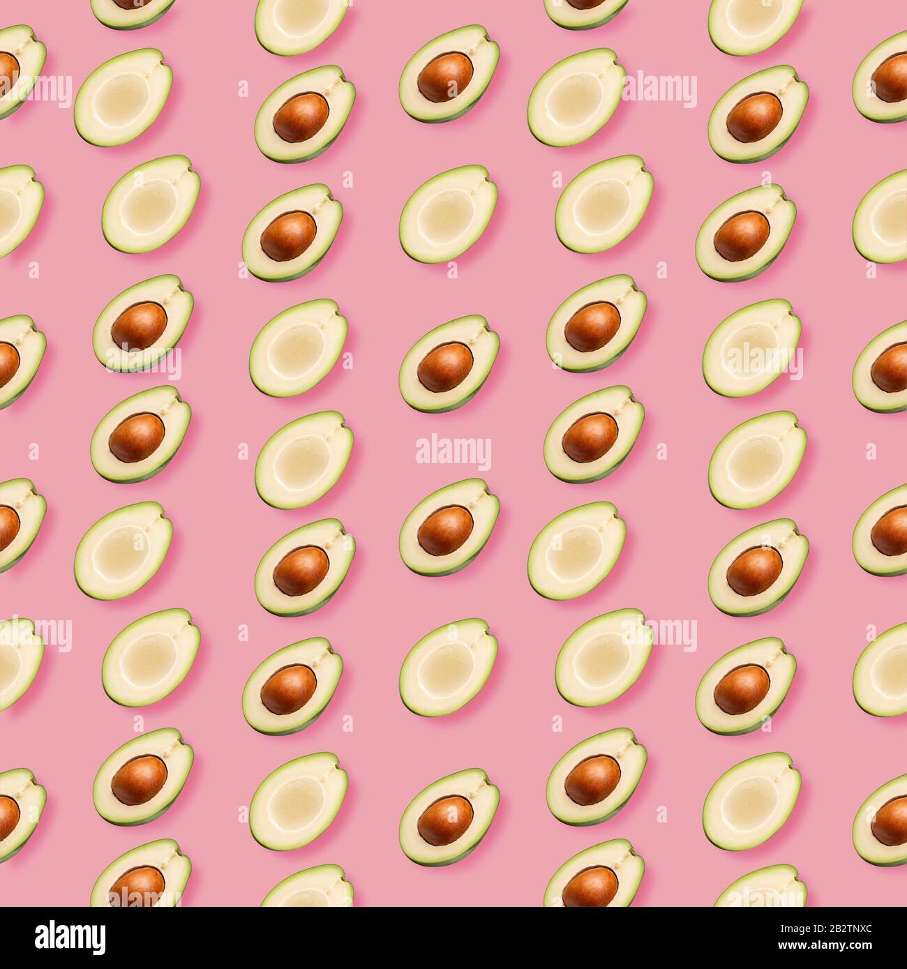 pattern con fette di avocado su sfondo rosa. Foto Stock