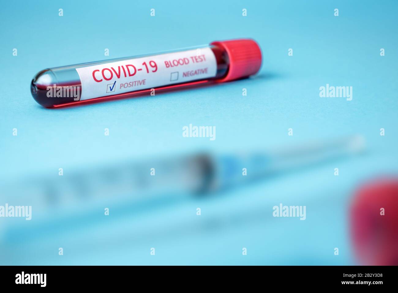 Provetta con campione di sangue per il test COVID-19, nuovo coronavirus 2019 trovato a Wuhan, Cina. Malattia di coronavirus: COVID-19. Sfondo blu Foto Stock