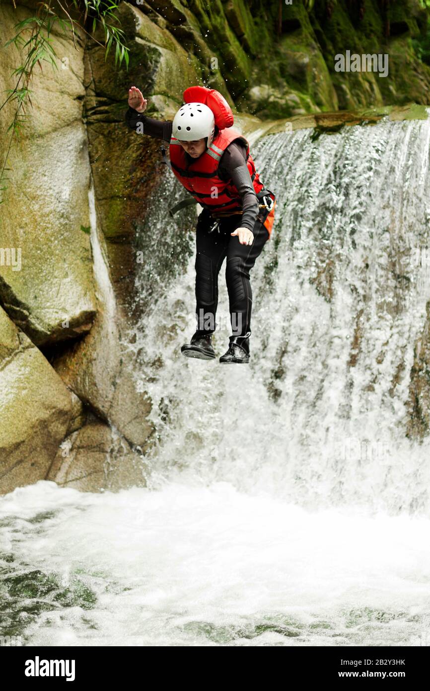 Donna Ben Attrezzata Che Salta In Una Piscina Naturale Durante Una Spedizione Canyoning Foto Stock