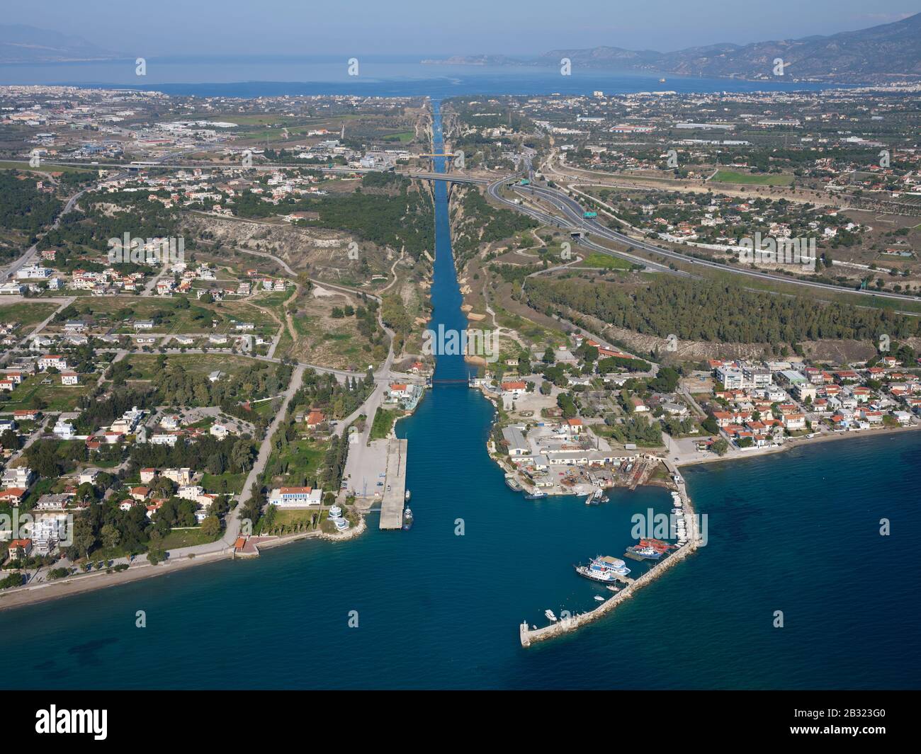 VISTA AEREA. Canale di Corinto lungo 6,4 km che collega il Golfo di Corinto in lontananza al Mar Egeo in primo piano. Istmo di Corinto, Grecia. Foto Stock