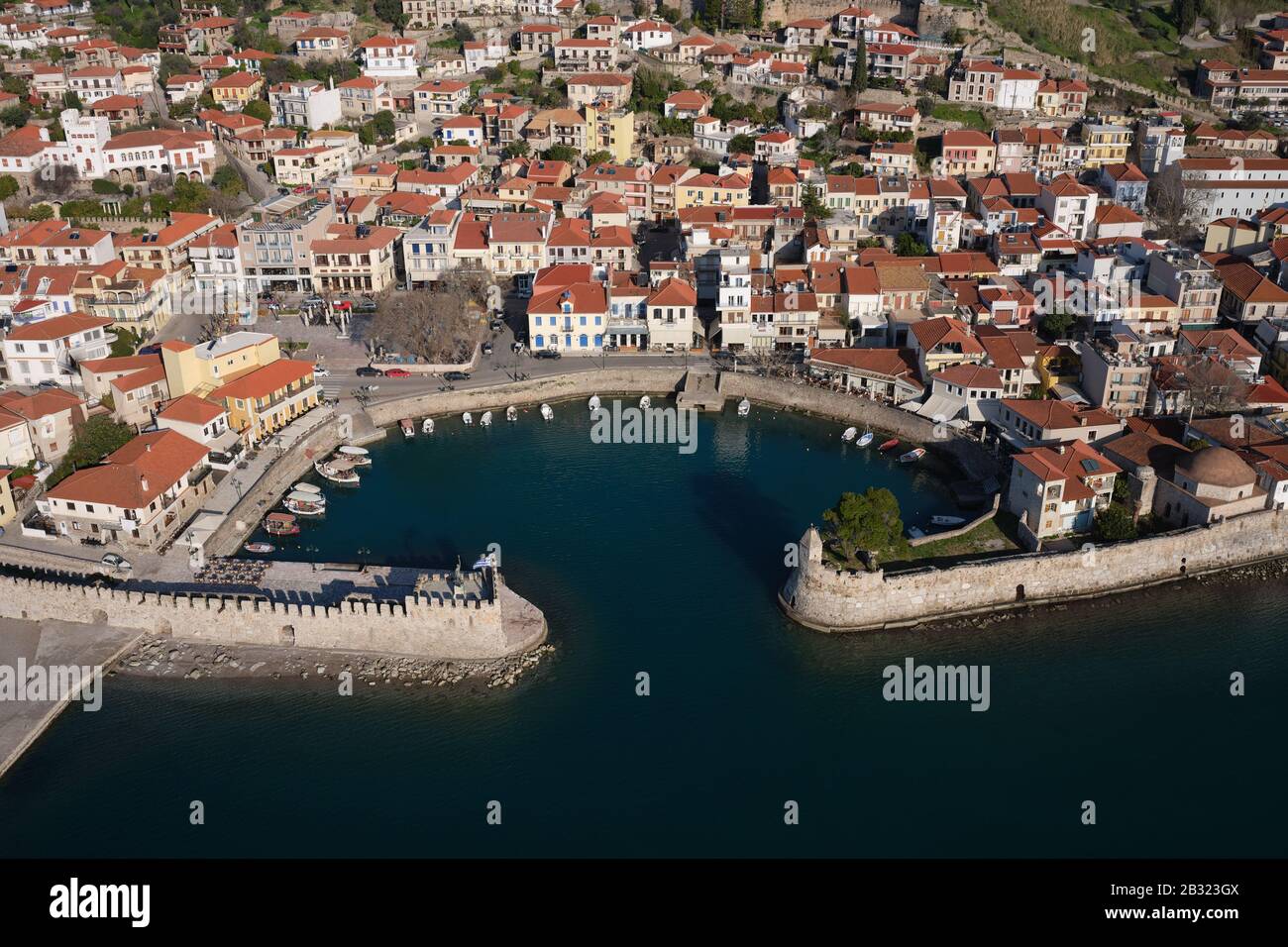 VISTA AEREA. Pittoresca cittadina di Nafpaktos con il suo piccolo porto fortificato. Golfo di Corinto, Grecia occidentale, Grecia. Foto Stock