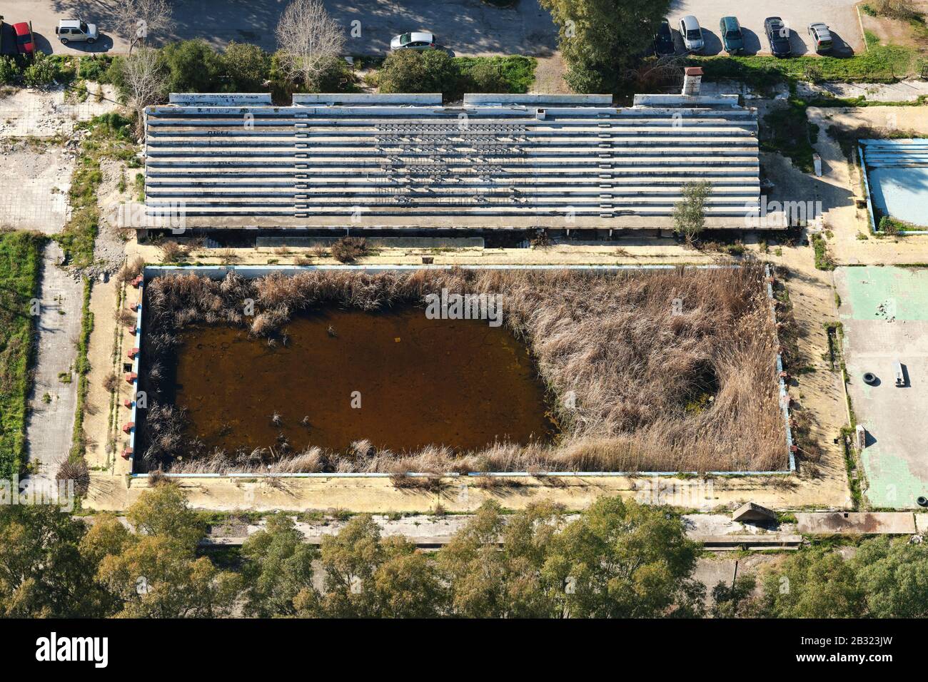 VISTA AEREA. Piscina olimpionica abbandonata rigenerata dalla vegetazione. Patrasso, Grecia occidentale, Penisola del Peloponneso, Grecia. Foto Stock
