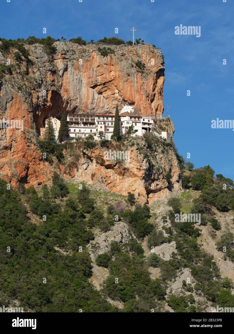 Monastero ortodosso costruito su una stretta sporgenza su una parete rocciosa (vista elevata dall'altro lato del canyon). Monastero di Elonas, Peloponneso, Grecia. Foto Stock