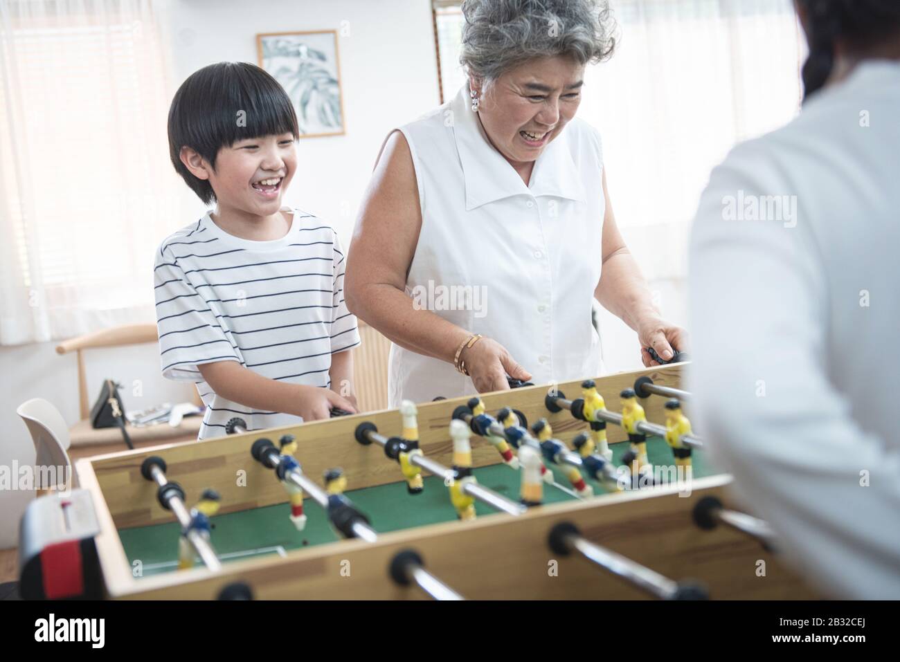 Gruppo di diversità età famiglia gioco da tavolo di calcio insieme felicemente. Nonna giocare insieme ai suoi figli a casa Foto Stock