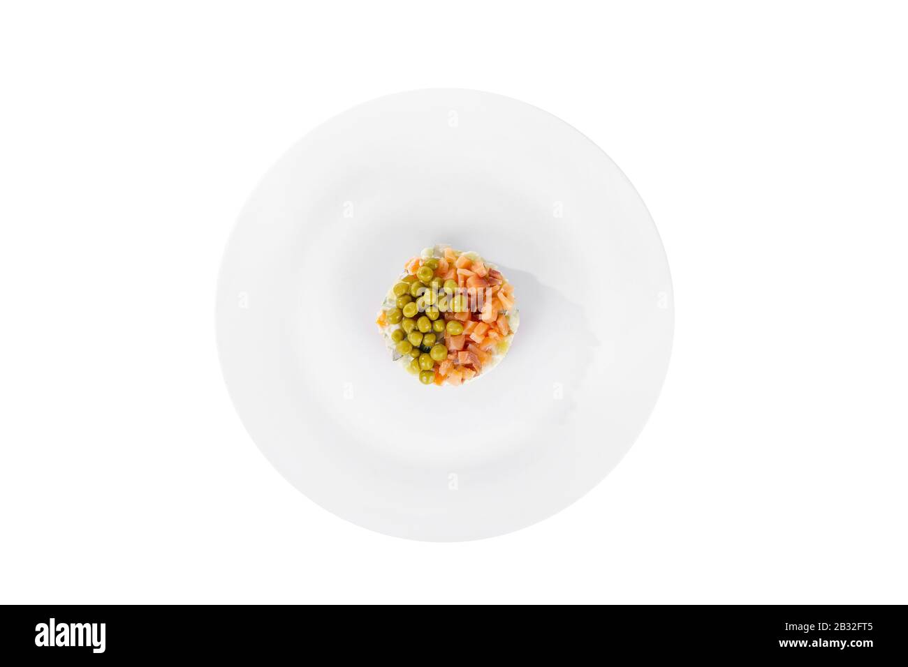 Insalata russa con piselli, pesce rosso, salmone al chum, uova, cetrioli, carote, patate su piastra, vista dall'alto, sfondo bianco isolato Foto Stock